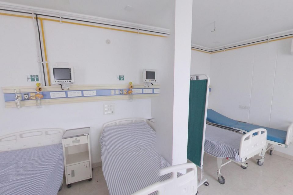 Two hospital beds below wall-mounted patient monitors and oxygen outlets